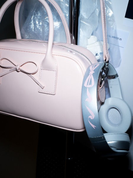 Collaborazione tra Beats e Sandy Liang. Borsa rosa pastello con un fiocco e le cuffie di Beats anche con un fiocco rosa, caratteristica della stilista newyorkese