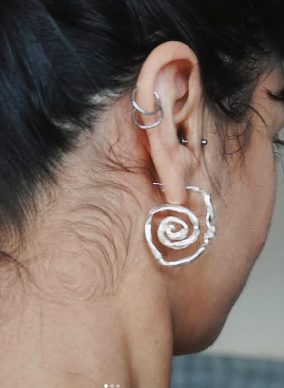 Orecchino di REASO in argento a forma di spirale martellato fatto a mano.