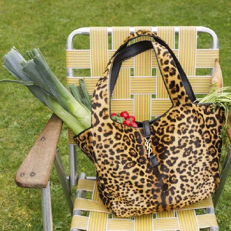 Borsa di Yves Saint Laurent leopardata fotografata da Martin Parr in un giardino con della verdura fresca dentro in un articolo relativo al cibo