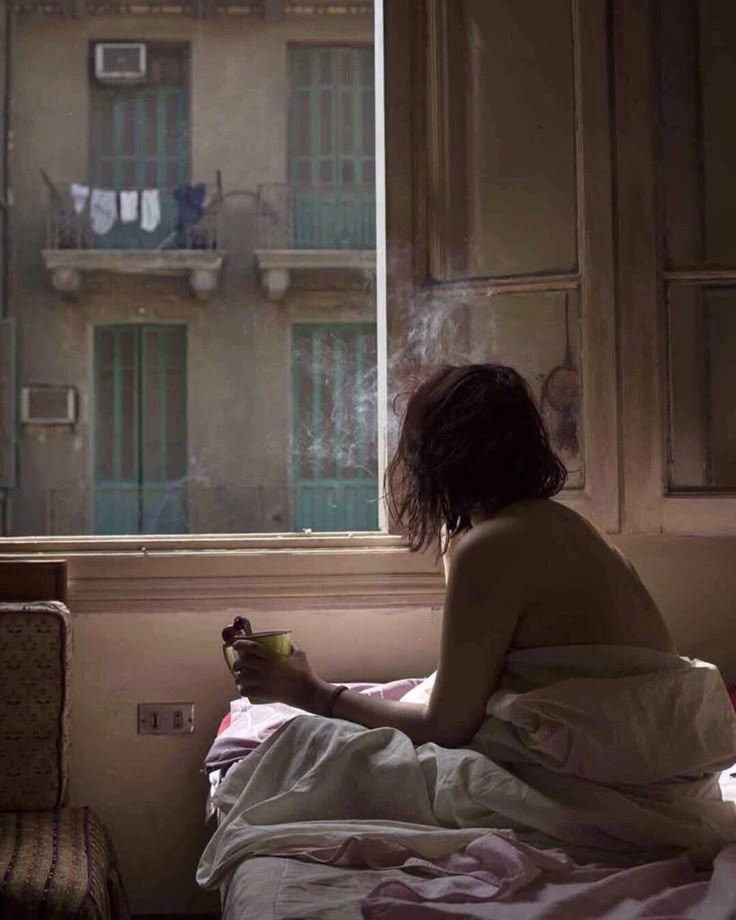 tempo che scorre: ragazza sulla finestra che guarda il vuoto, immersa nei pensieri