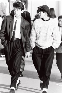 Streetstyle giapponese degli anni 80. Due ragazzi che camminano, uno con un tailleur leggero nero. L'altro con un maglione pesante bianco e un cappello