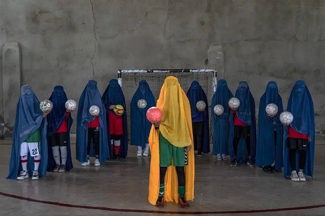Squadra di calcio di ragazze afghane, tutte coperte con una palla da calcio in mano. 