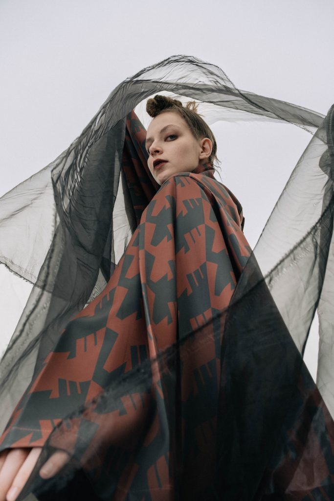 Campagna SS26 del brand INF, modella che indossa una camicia con una stampa rossa e nera originale del brand