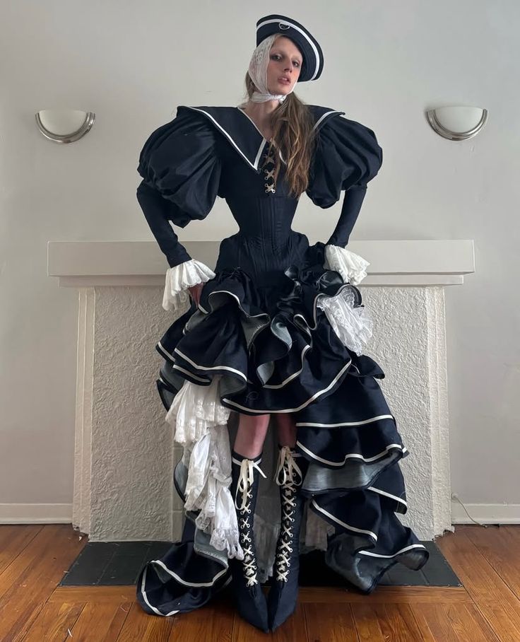 Look ispirato alle divise mariniere di Erik Charlotte. La modella posa con teatralità all'interno di un appartamento