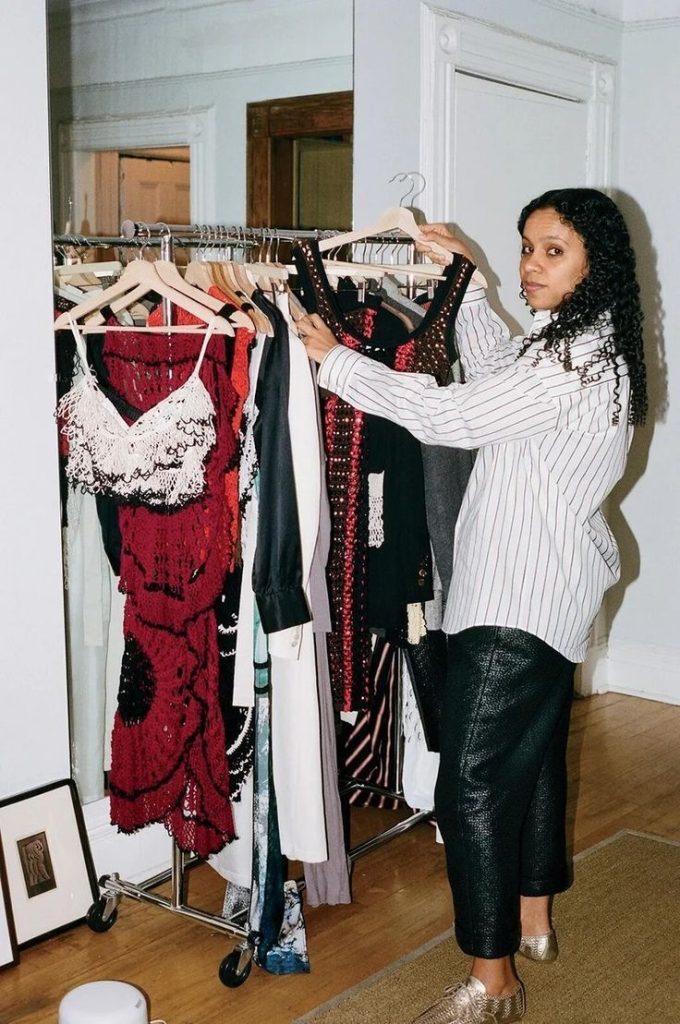 Rachel Scott insieme ai suoi disegni. Designer immigrato dalla Giamaica a New York per fare del suo brand un successo e diventare direttrice creativa di Proenza Schouler