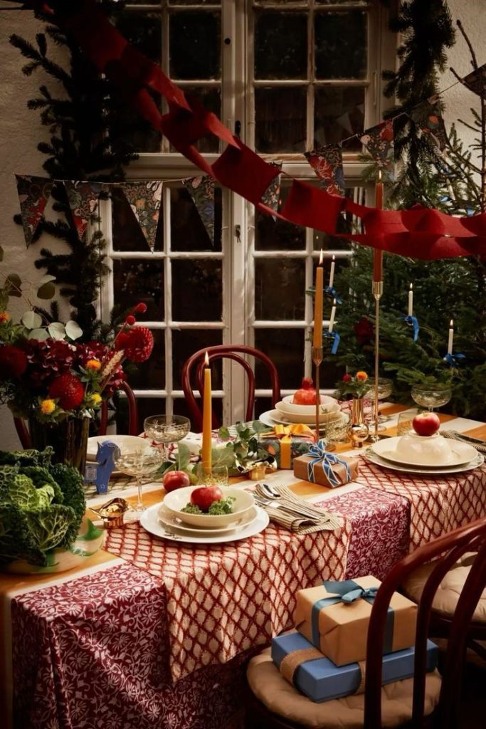 Tavola di natale decorata con luci e palline natalizie e tanto cibo
