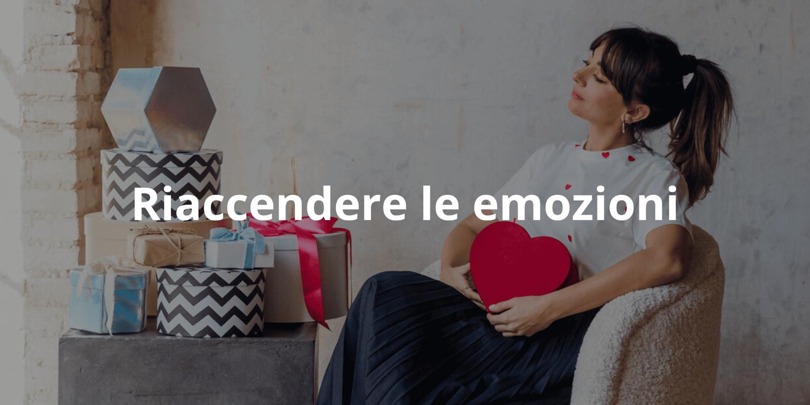Ilaria seduta su una poltrona con cuscino a forma di cuore, circondata da scatole regalo