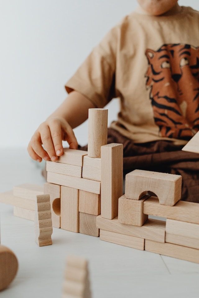 Un bambino che gioca con le costruzioni di legno