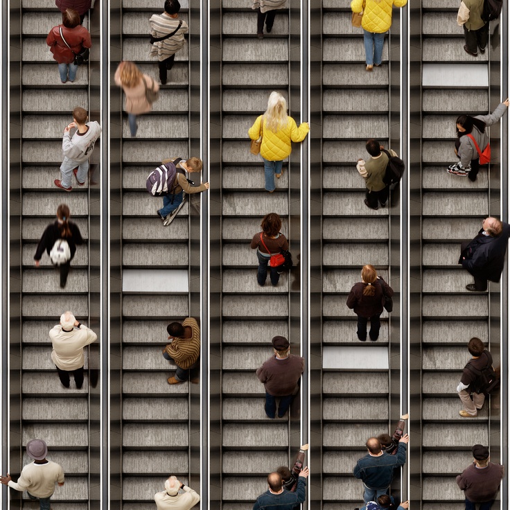 Immagine di scale mobili con diverse persone.