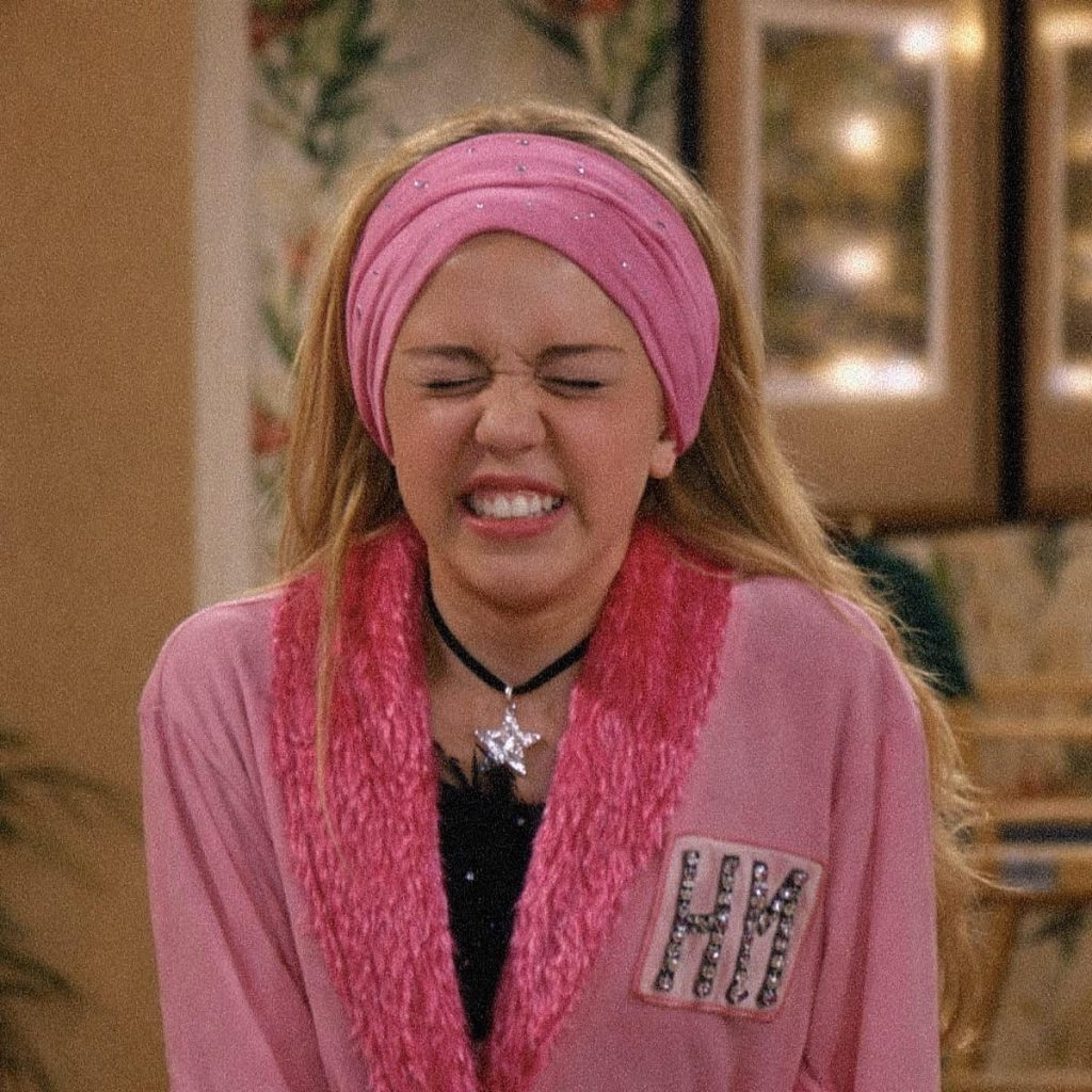 Hannah appare con un look super pop e colorato, mentre stringe gli occhi e fa una smorfia esagerata