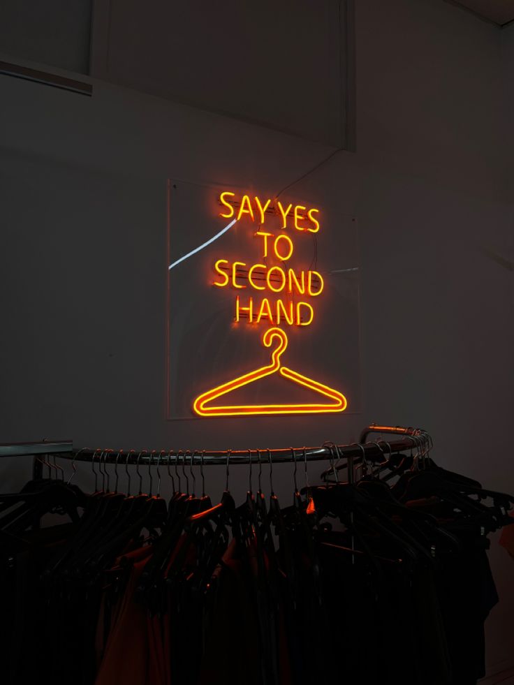 insegna luminosa che promuove second hand in negozio di abbigliamento sostenibile
