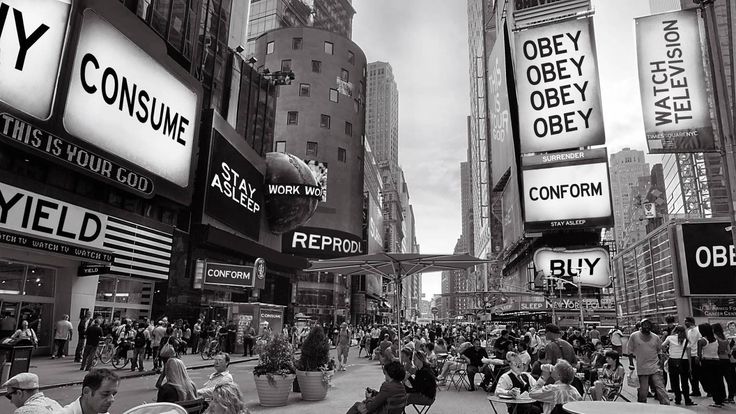“Cartelloni con messaggi subliminali come ‘OBEY’ e ‘CONSUME’ ispirati all’estetica del film They Live di John Carpenter”
