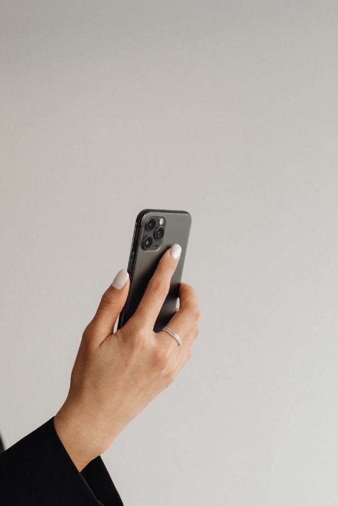 Immagine di una mano con telefono.
