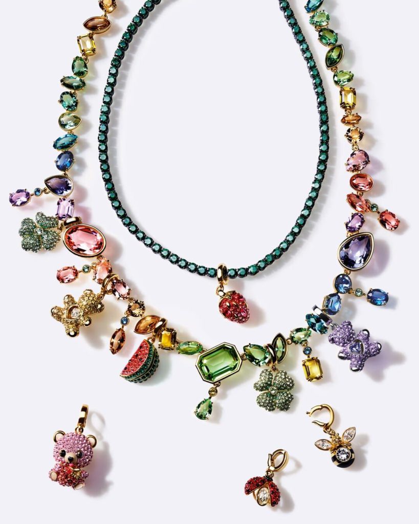 Composizione di Swarovski Charms estivi con dettagli a forma di frutta, api e simboli portafortuna.