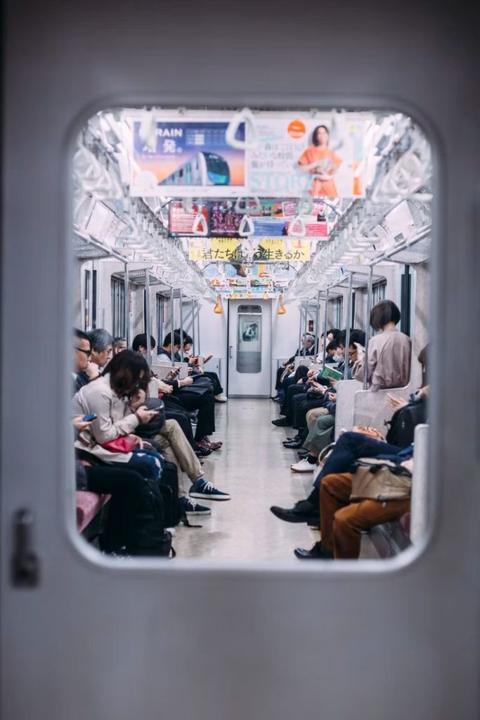 Immagine di una metro con sedute diverse persone.
